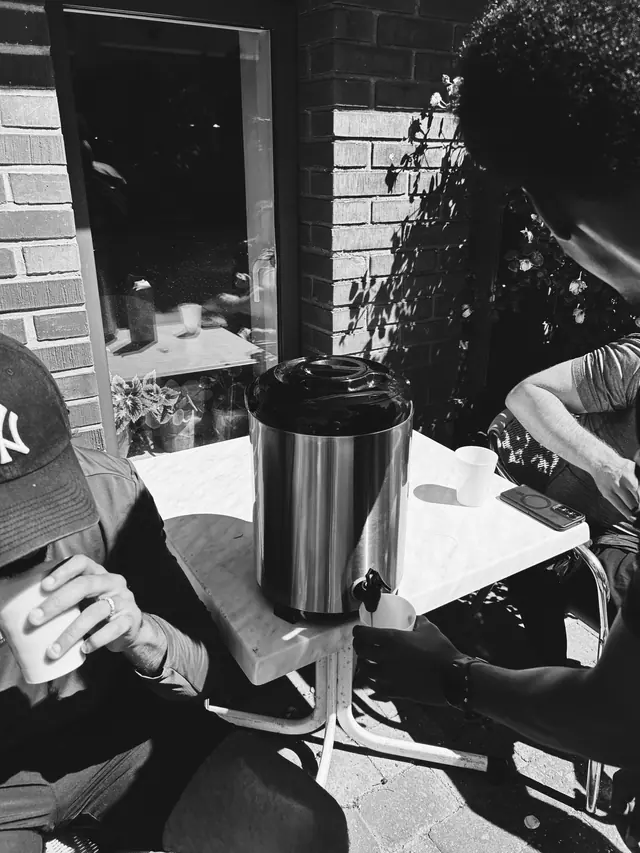 A coffee urn and cups on a table