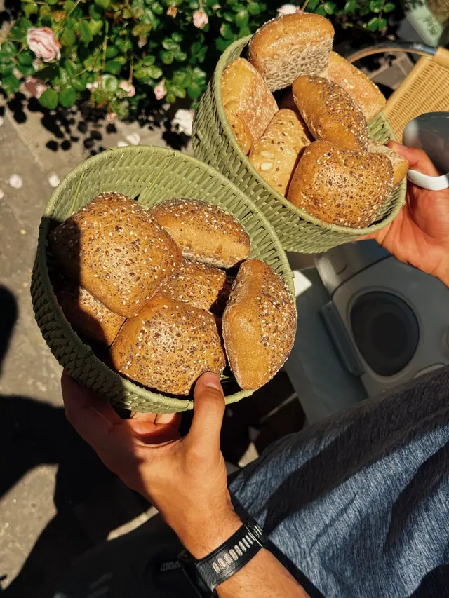 Hands holding a basket of buns