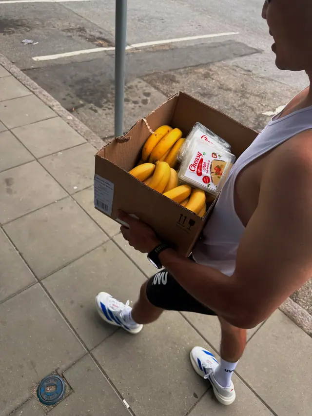 A runner carrying a box of bananas