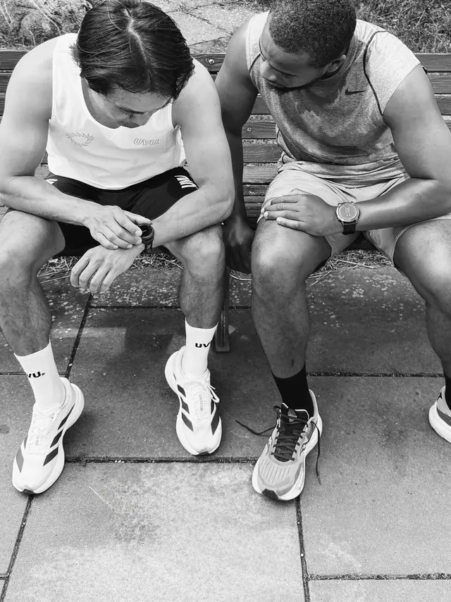 Two runners sitting on the kerb