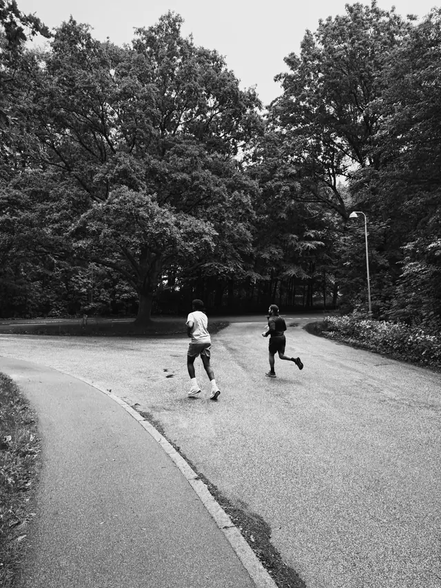 A wide empty road with two runners