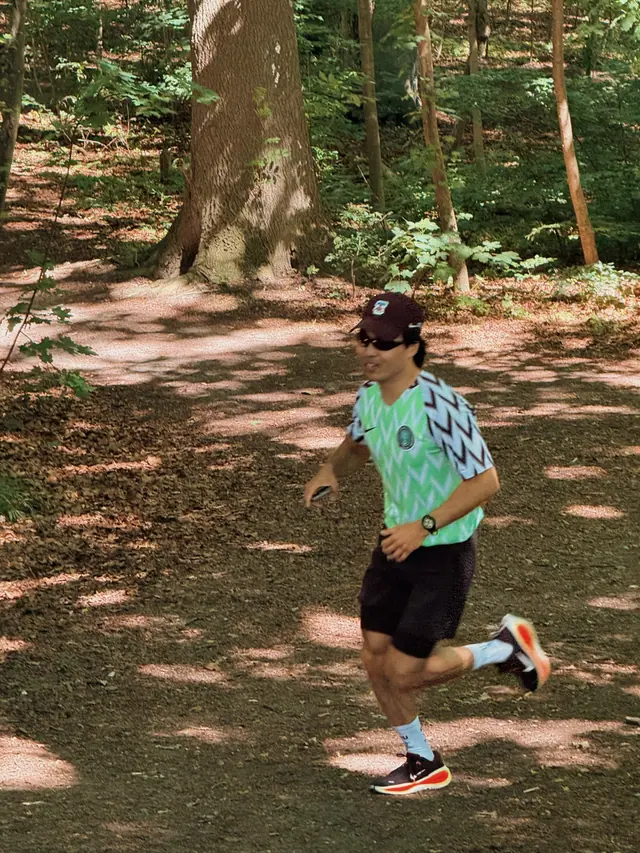 A runner in dappled woodland