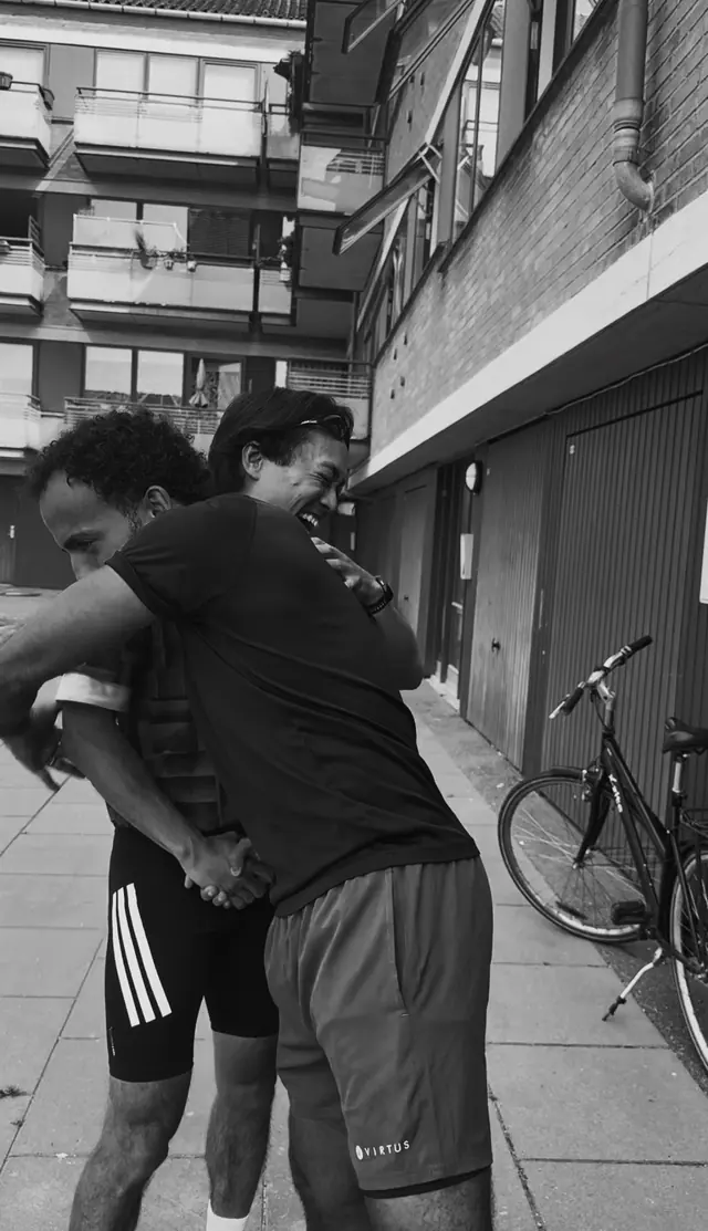 Two runners embracing after a run