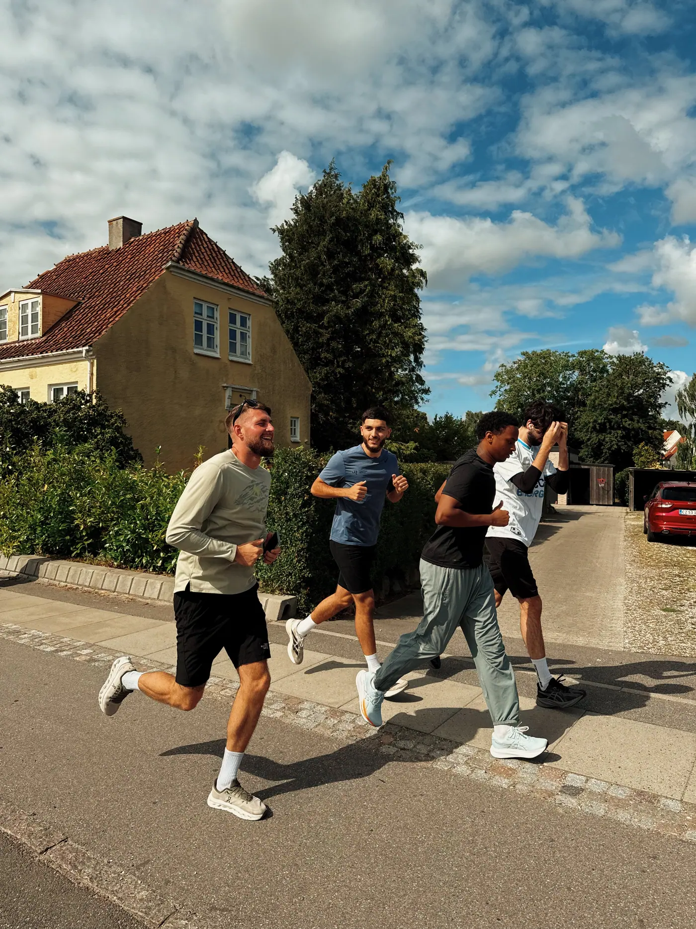 A group running down a sunlit street