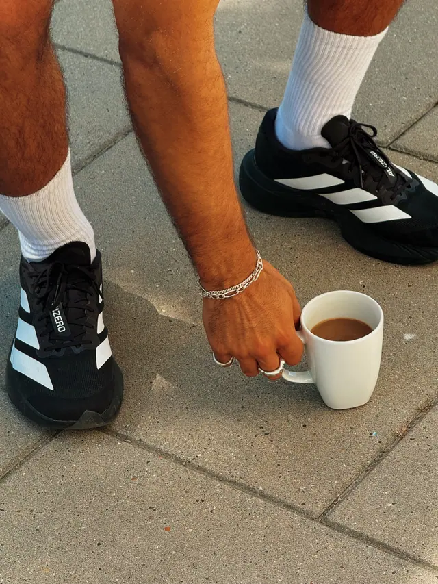 A hand reaching for a cup of coffee